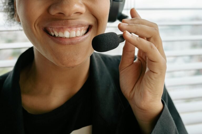 Close-up of a smiling call center representative holding a microphone.